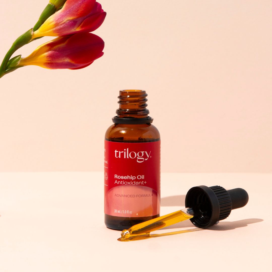 Rosehip Oil Antioxidant+ with a dropper and a flower.