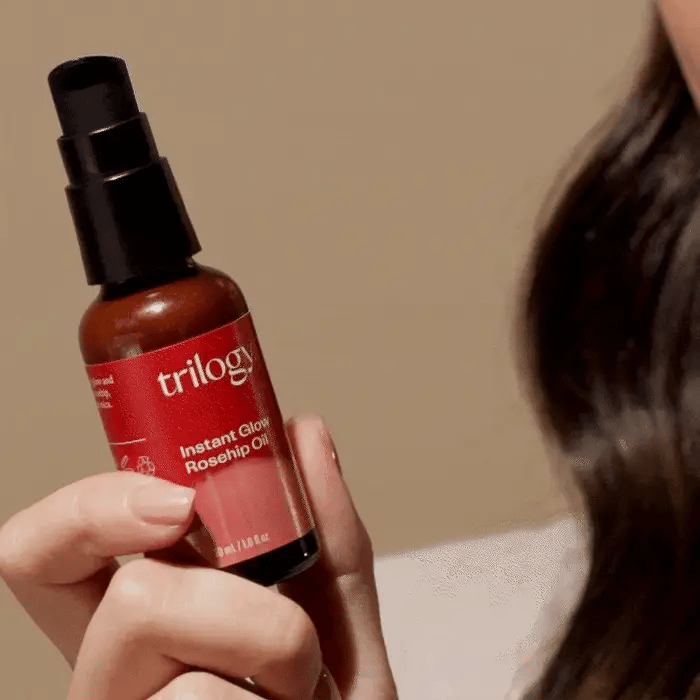 Instant Glow Rosehip Oil bottle in model hand.
