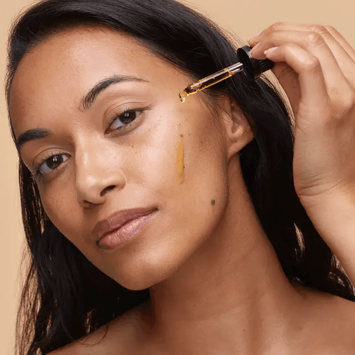 Trilogy Skincare Rosapene Bakuchiol Oil with dropper on model.