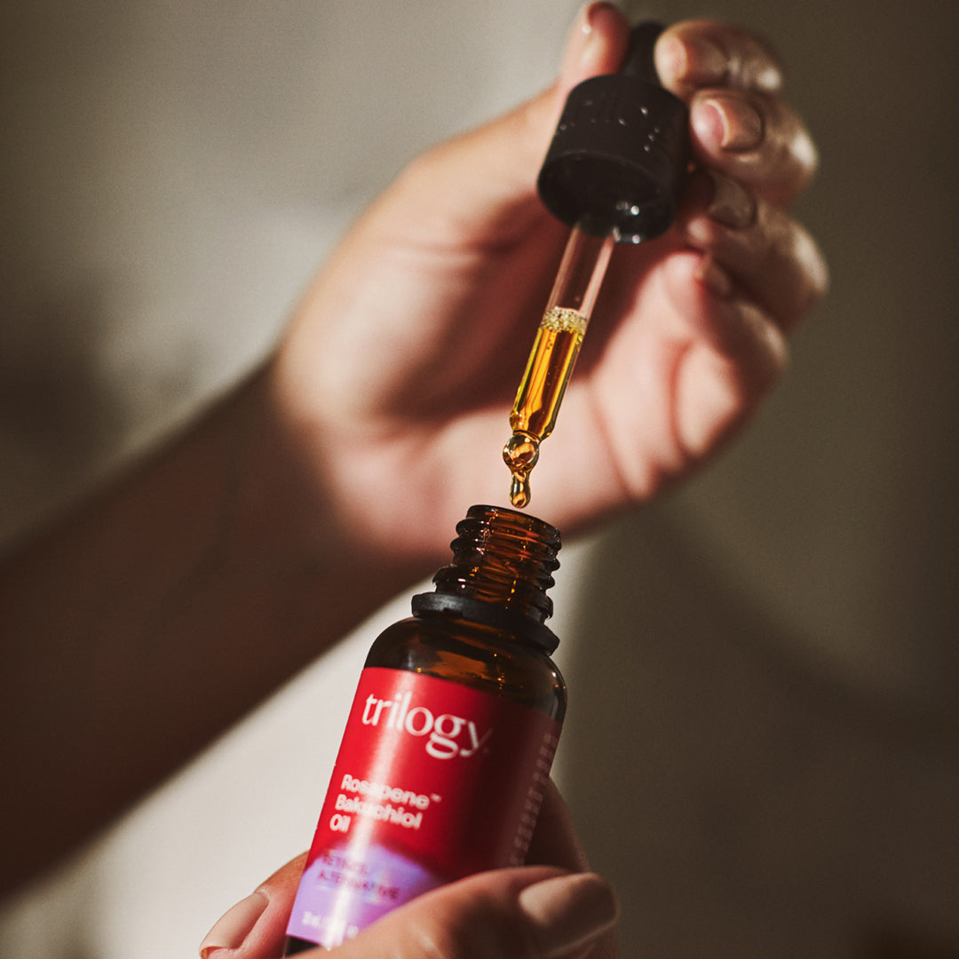 Trilogy Skincare Rosapene Bakuchiol Oil, 30ml with dropper in hand.
