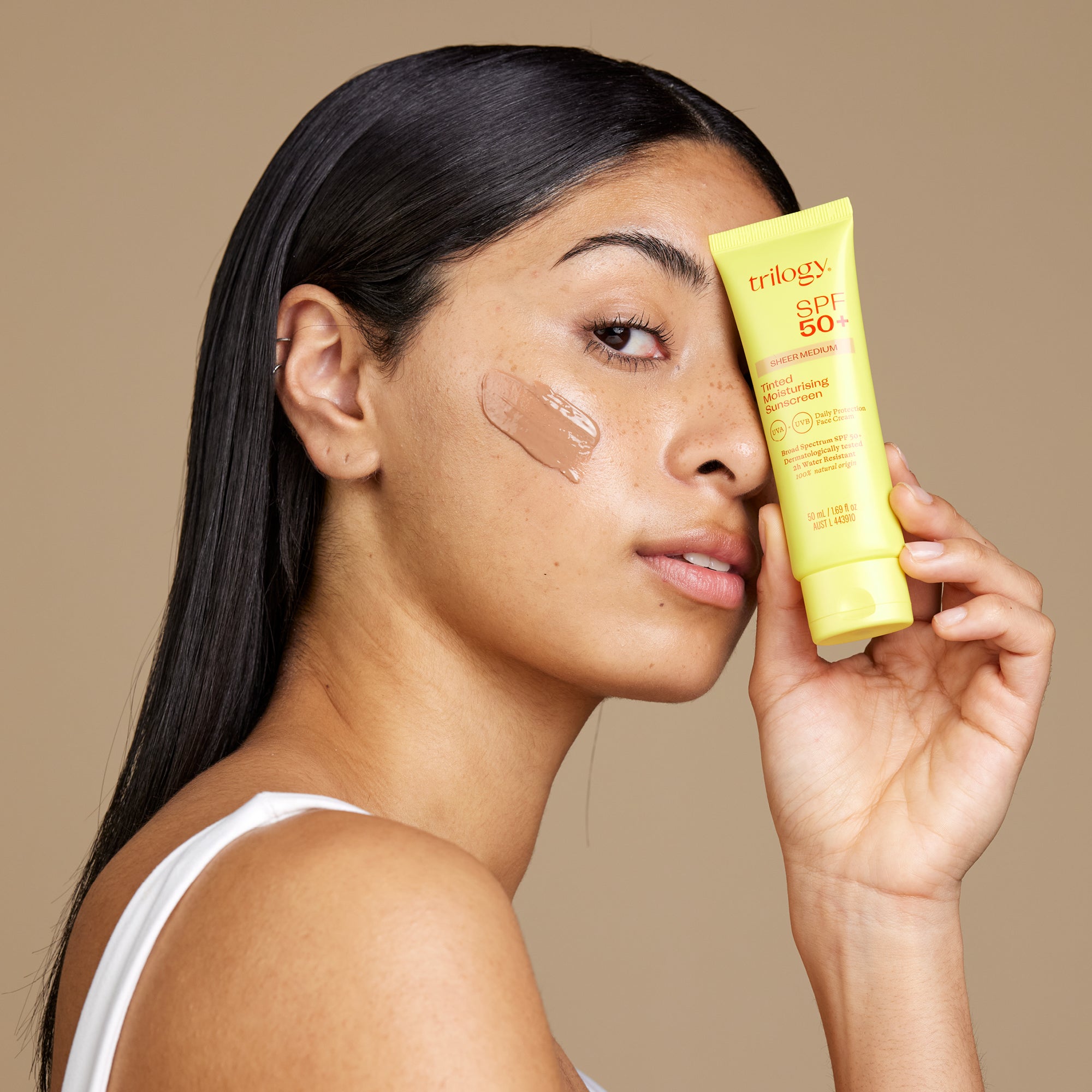 SPF 50+ Sheer Tinted Moisturising Sunscreen medium with model and product.