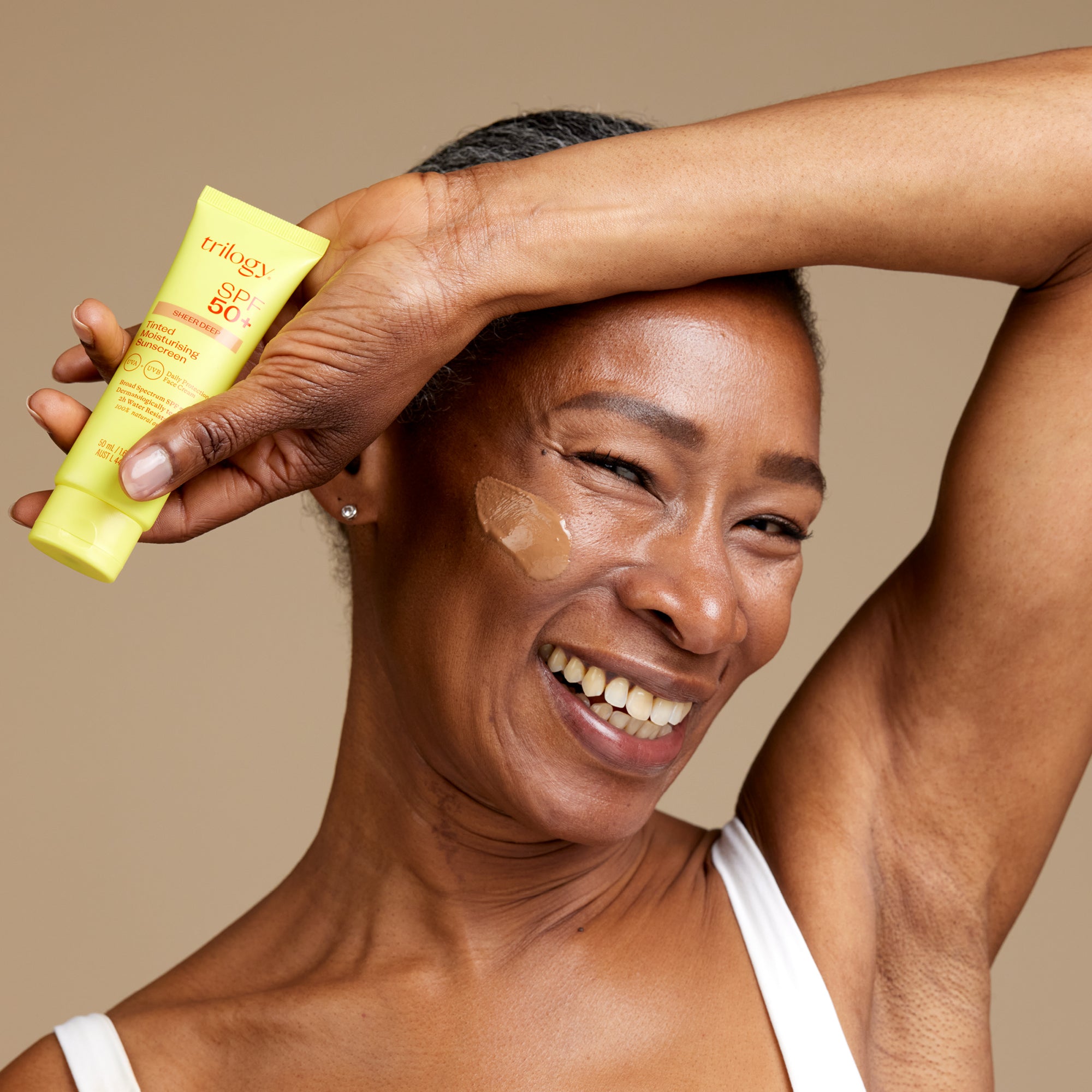 SPF 50+ Sheer Tinted Moisturising Sunscreen model with deep shade.