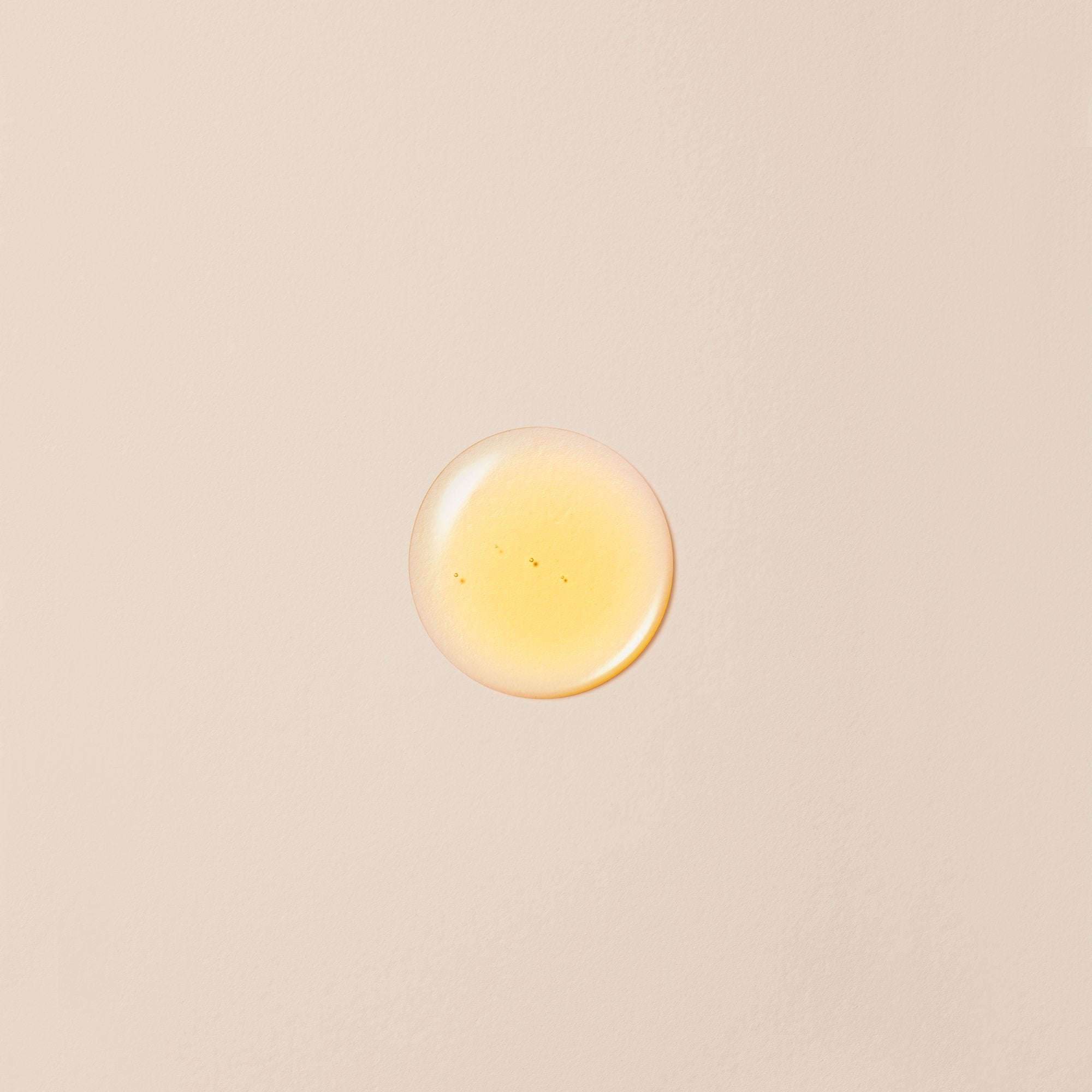 CoQ10 Booster Oil swatch on beige background.